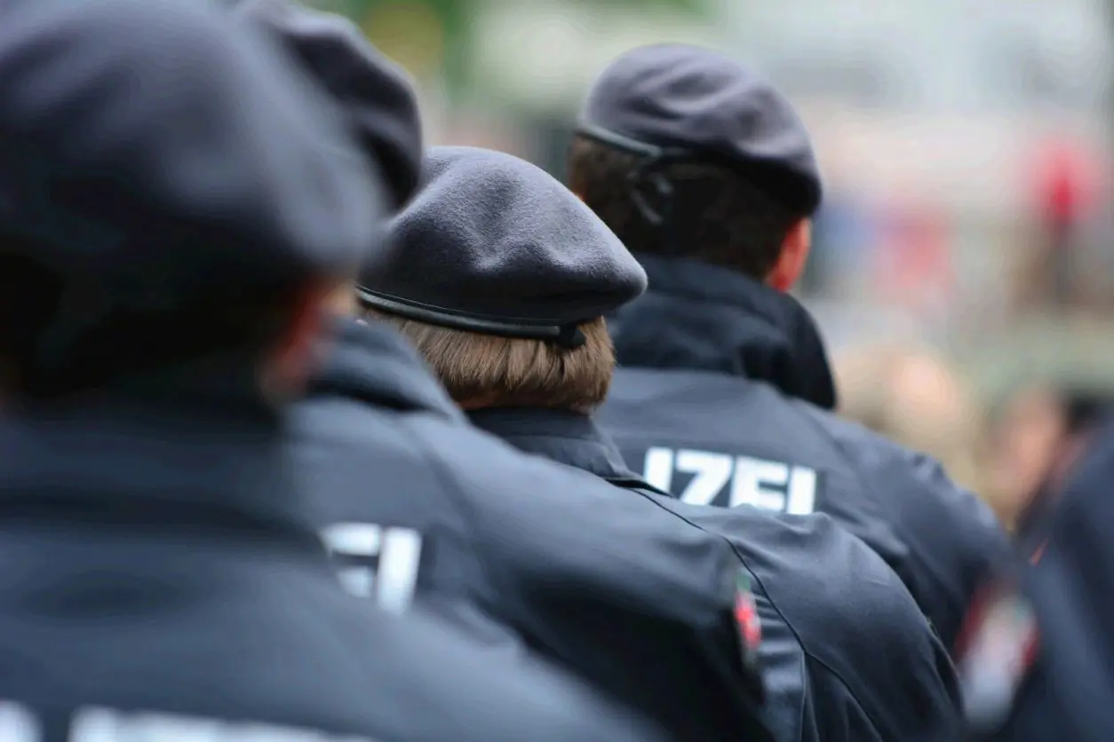 Police officers in uniform standing in a line outdoors.