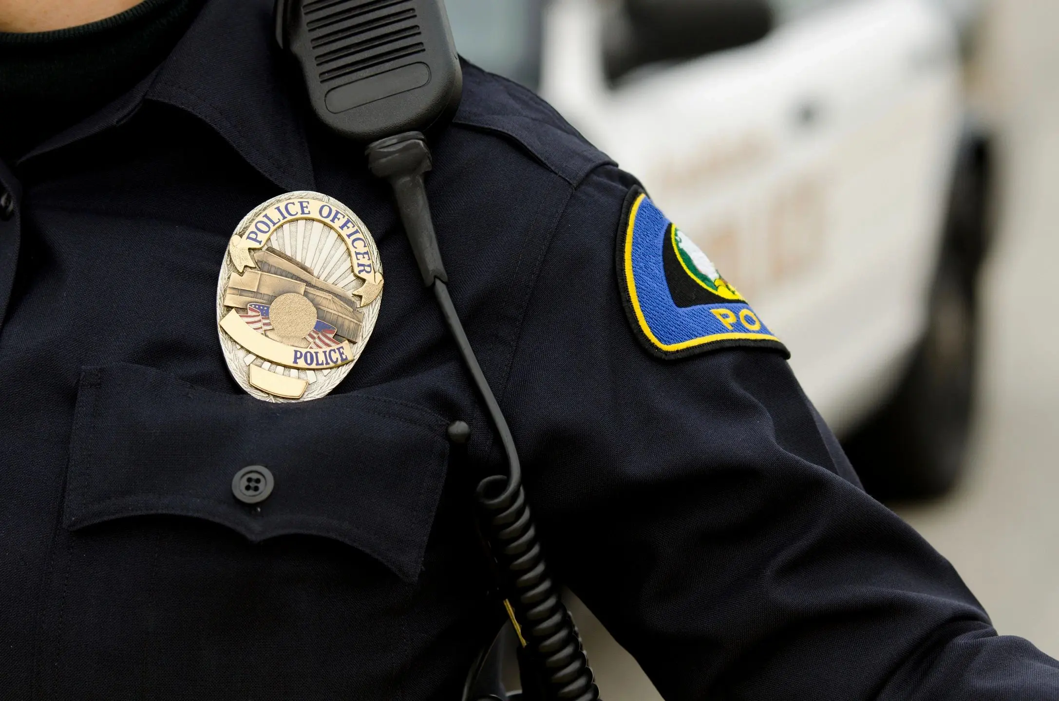 Close-up of a police officer's badge and uniform patch.