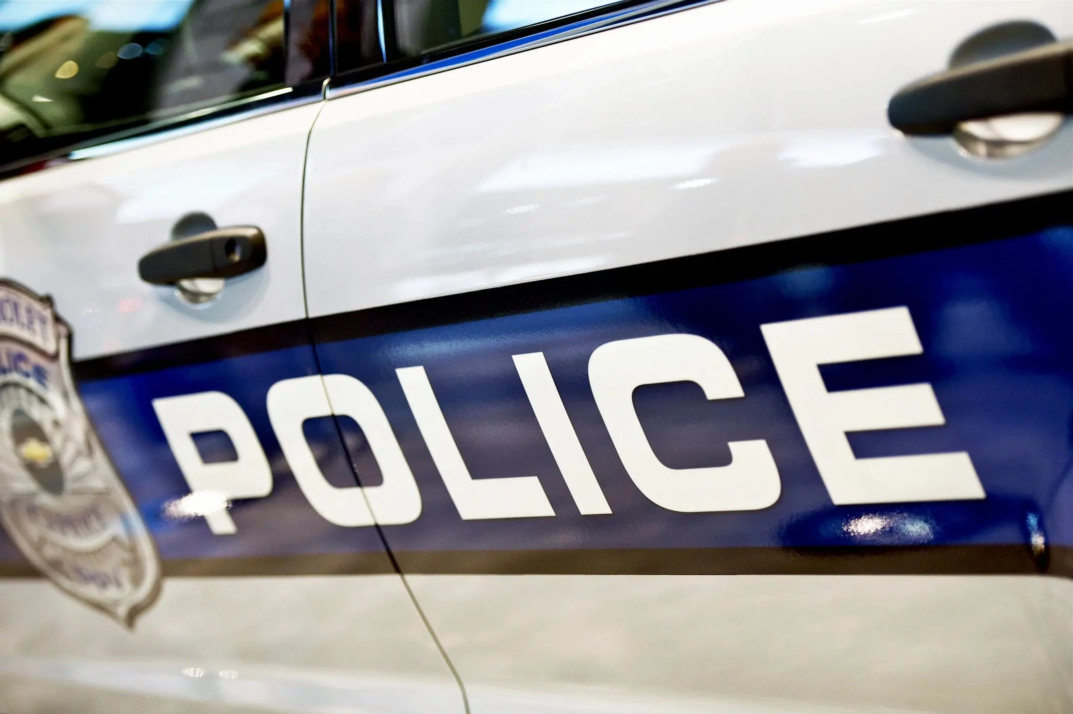 Close-up of a police car door with the word POLICE visible.