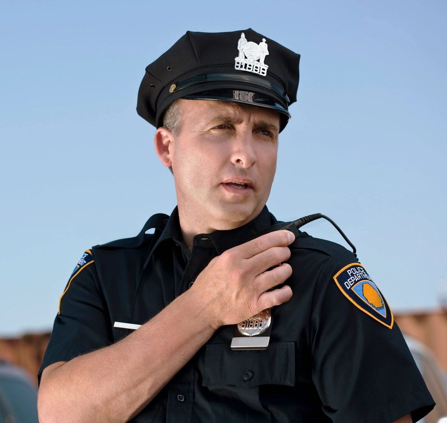 Police officer speaking into a radio.